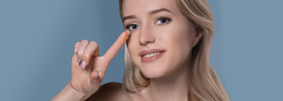 ragazza bionda sorridente mostra una lente a contatto