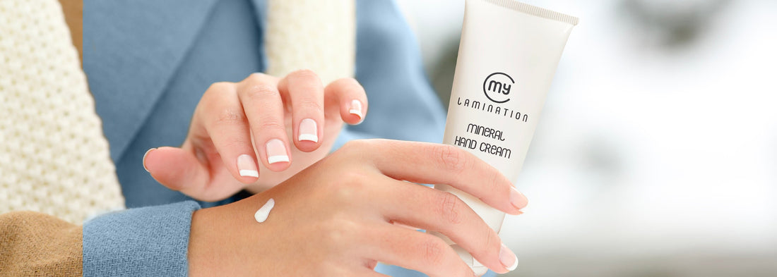 primo piano sulle mani di una donna mentre si spalma la crema idratante per le mani di my lamination