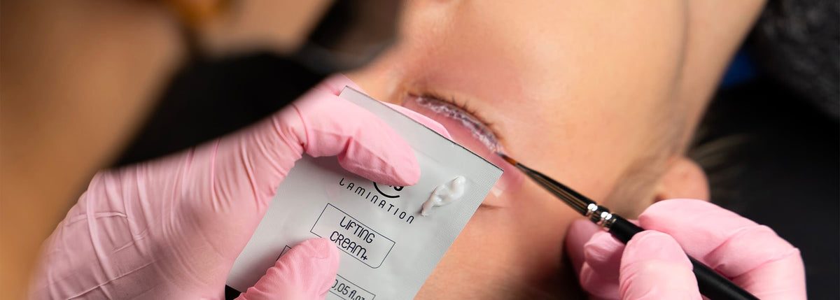 estetista esegue laminazione ciglia su una cliente reggendo la lifting cream di my lamination