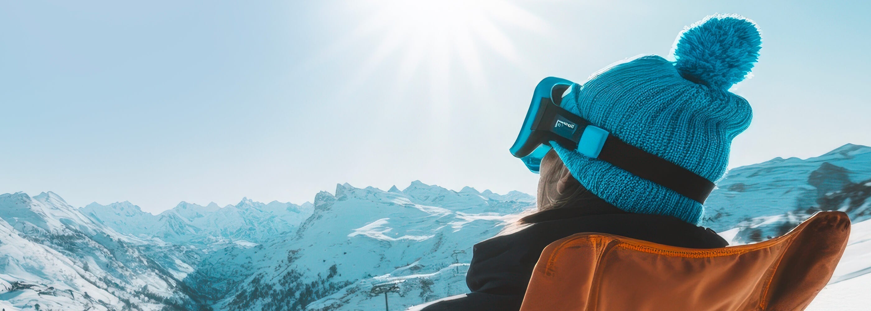 ragazza su uno sdraio che prende il sole in un paesaggio di montagna innevato
