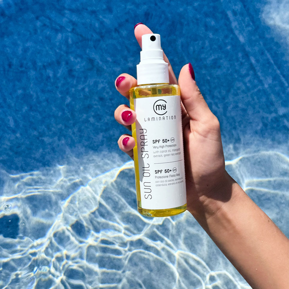 mano impugna un olio solare di my lamination in piscina